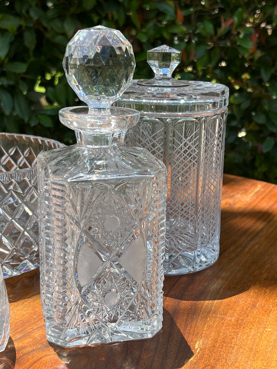 Elegante Bottiglia da whisky in cristallo molato con decoro a sole e geometrico con tappo sfaccettato.  Misure 10x10x25h cm